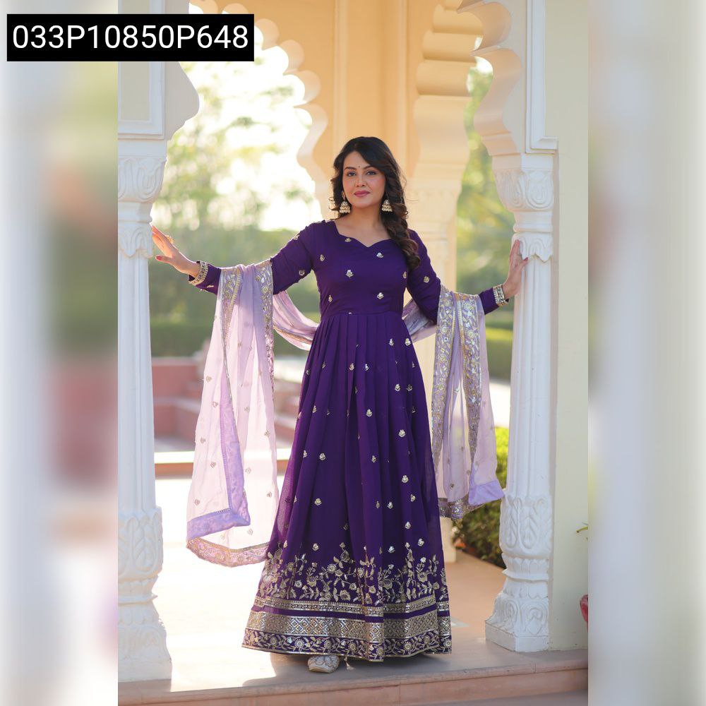 Elegant woman in a purple Star Georgette embroidered gown with sequins work, posing in a traditional archway.