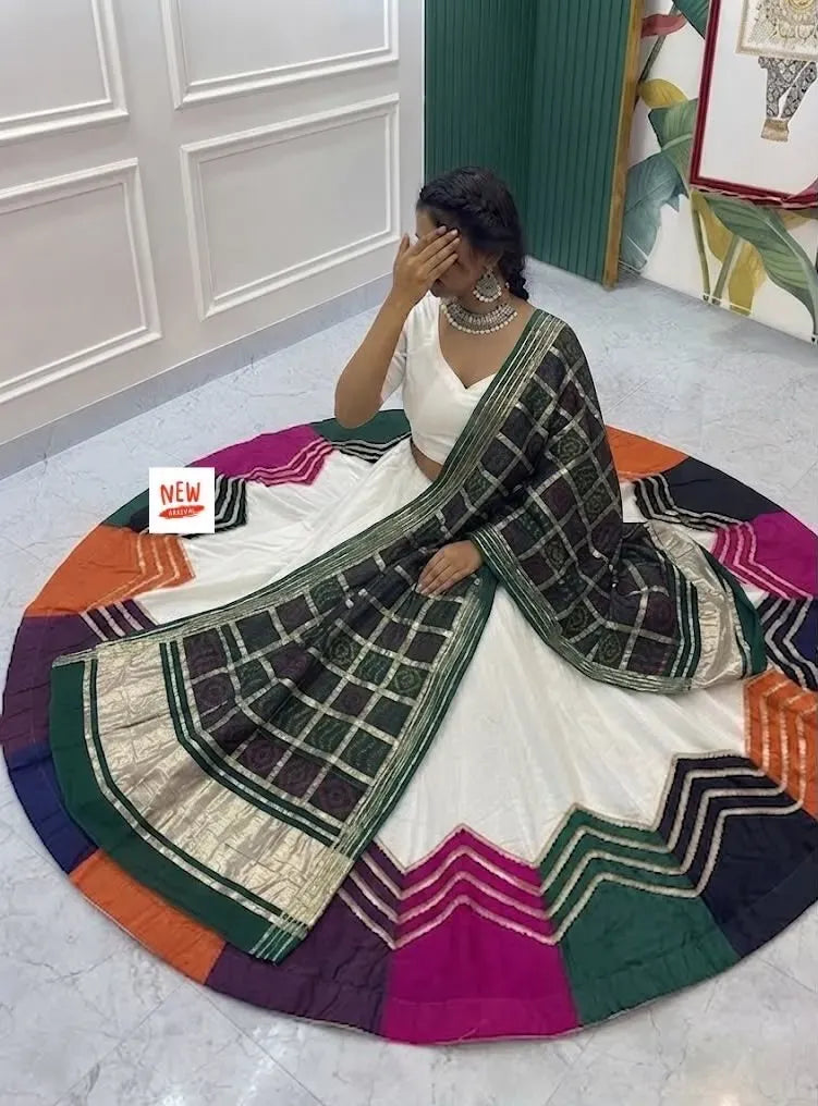 Model wearing white lehenga with multi-color panels and green checkered dupatta