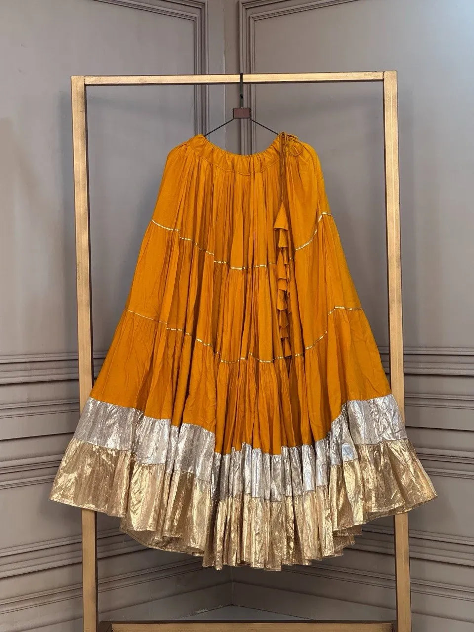 Bright mustard yellow flared rayon lehenga skirt showing standard frill stitching and gold lace