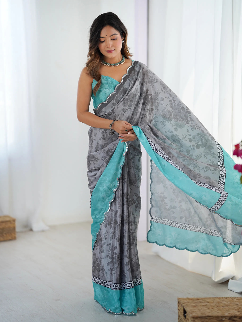 Model wearing grey and teal chinnon saree with mirror lace border