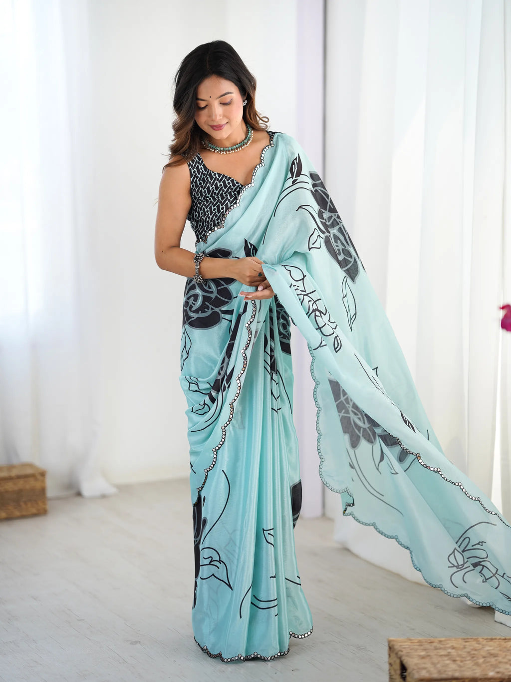 Model wearing sky blue chinnon saree with black floral print