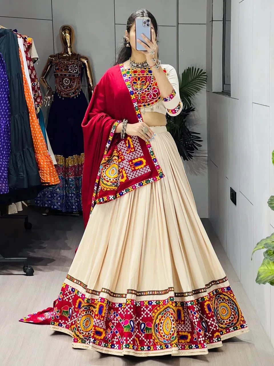 Front view of woman wearing vanilla and red mirror work lehenga choli