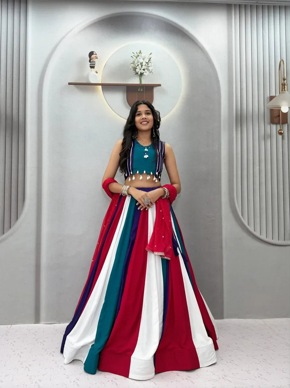 Front facing portrait of a smiling model wearing a multi-color striped cotton lehenga choli