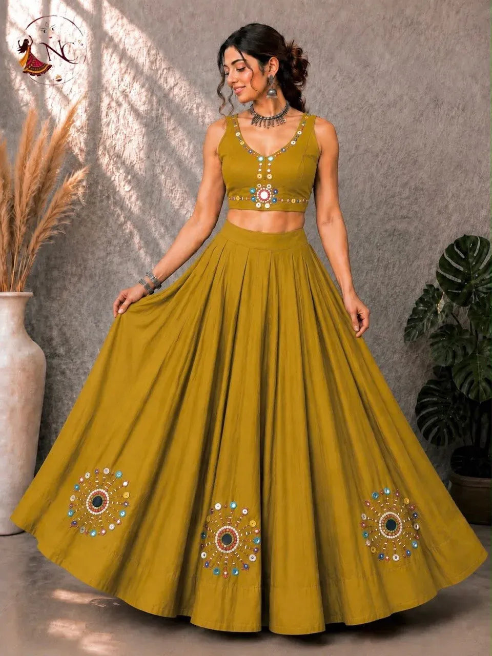 Front view of woman wearing yellow Roman silk lehenga choli with mirror work