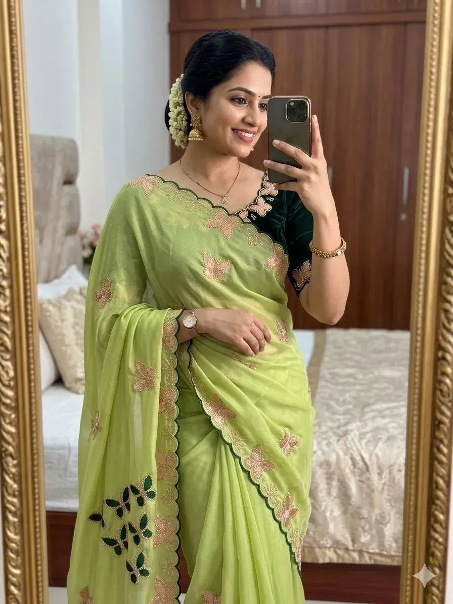 Woman wearing light green star georgette saree with embroidered border and blouse