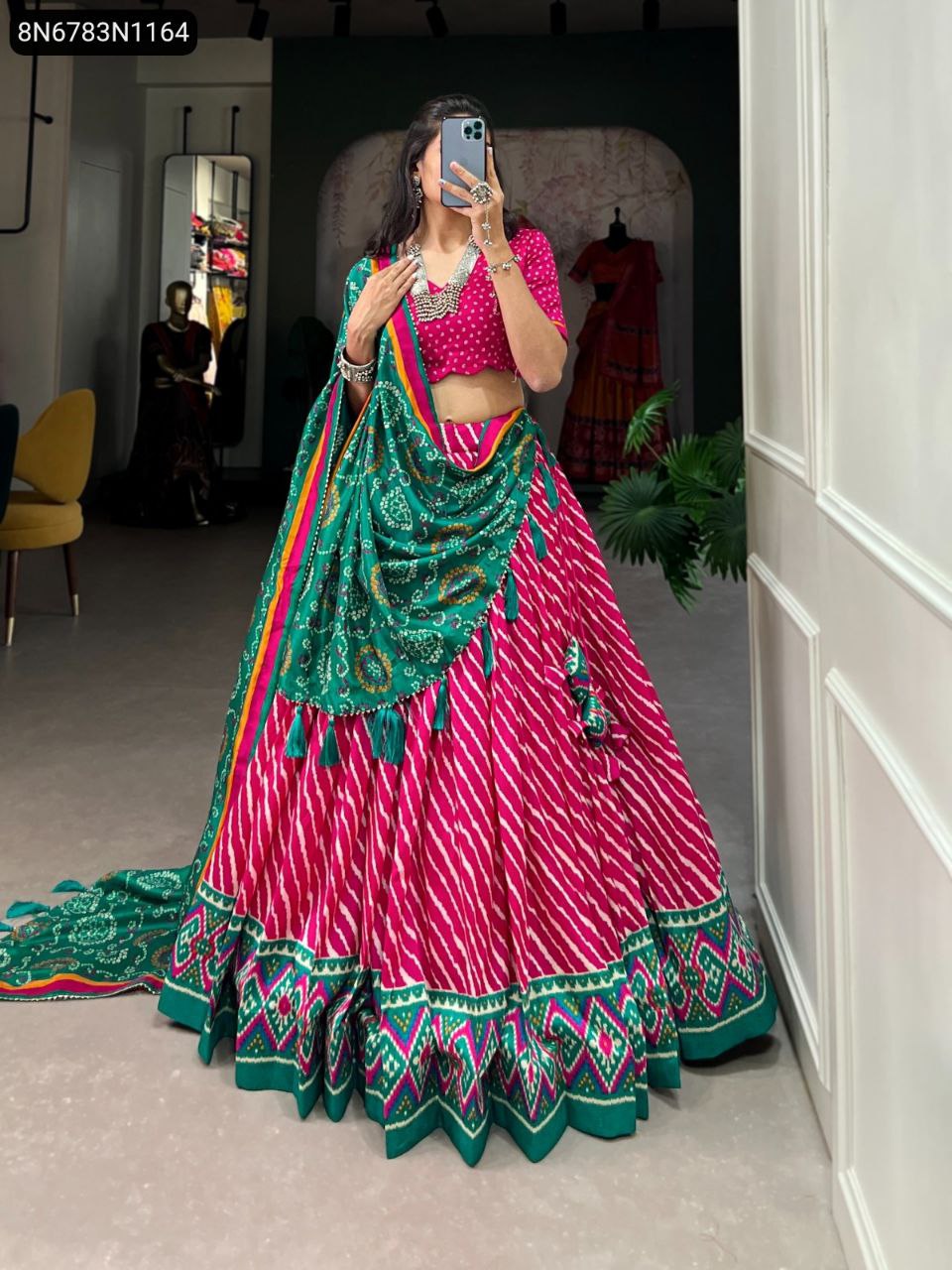 TRENDBUY Rani Pink and Green Tasar Silk Printed Lehenga Choli with full flair and contrasting dupatta, worn by a woman taking a mirror selfie.