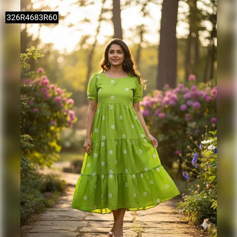 A woman happily walking on a garden path, wearing a green tiered maxi dress with white daisy floral print.