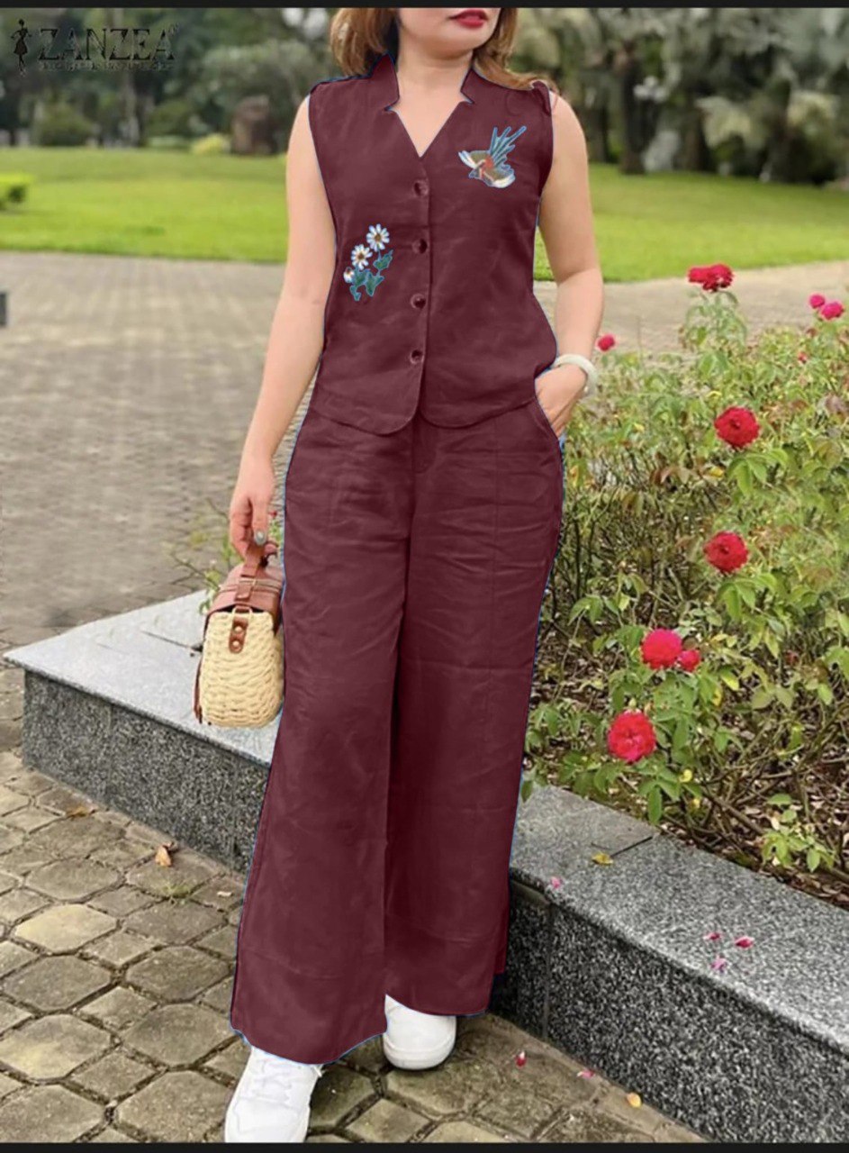 Woman in burgundy cotton slub aari work palazzo set with bird and flower embroidery, outdoors.