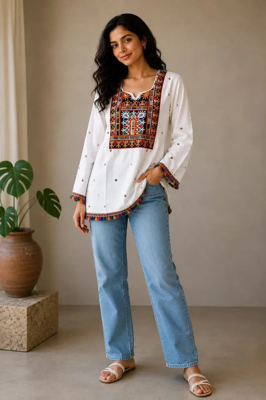 Model wearing white rayon top with mirror embroidery and blue jeans standing