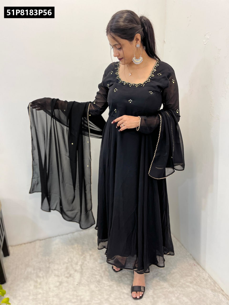 Full body shot of a model elegantly posing in the TRENDBUY black georgette anarkali gown, holding the dupatta, highlighting the 8-meter flair and graceful drape.