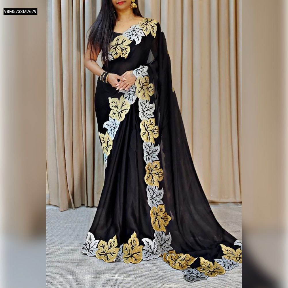 Model gracefully posing in the TRENDBUY Black Vichitra Silk Saree, elegantly draped, featuring a captivating border with golden and silver zari leaf work, perfect for festive and traditional occasions.