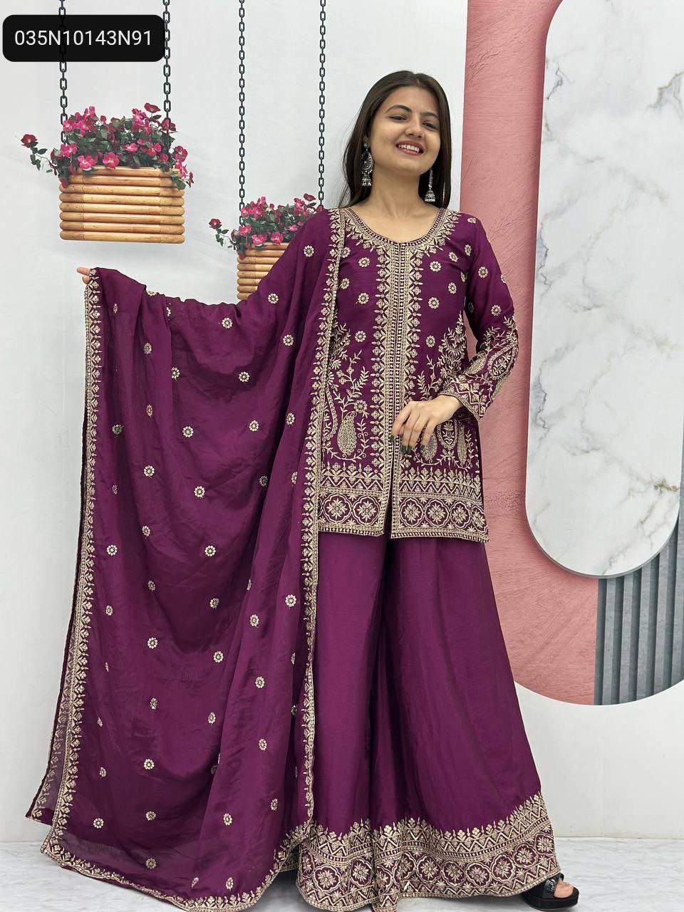 Full-body model shot of a smiling woman in a wine purple embroidered palazzo suit, with a matching dupatta elegantly draped.