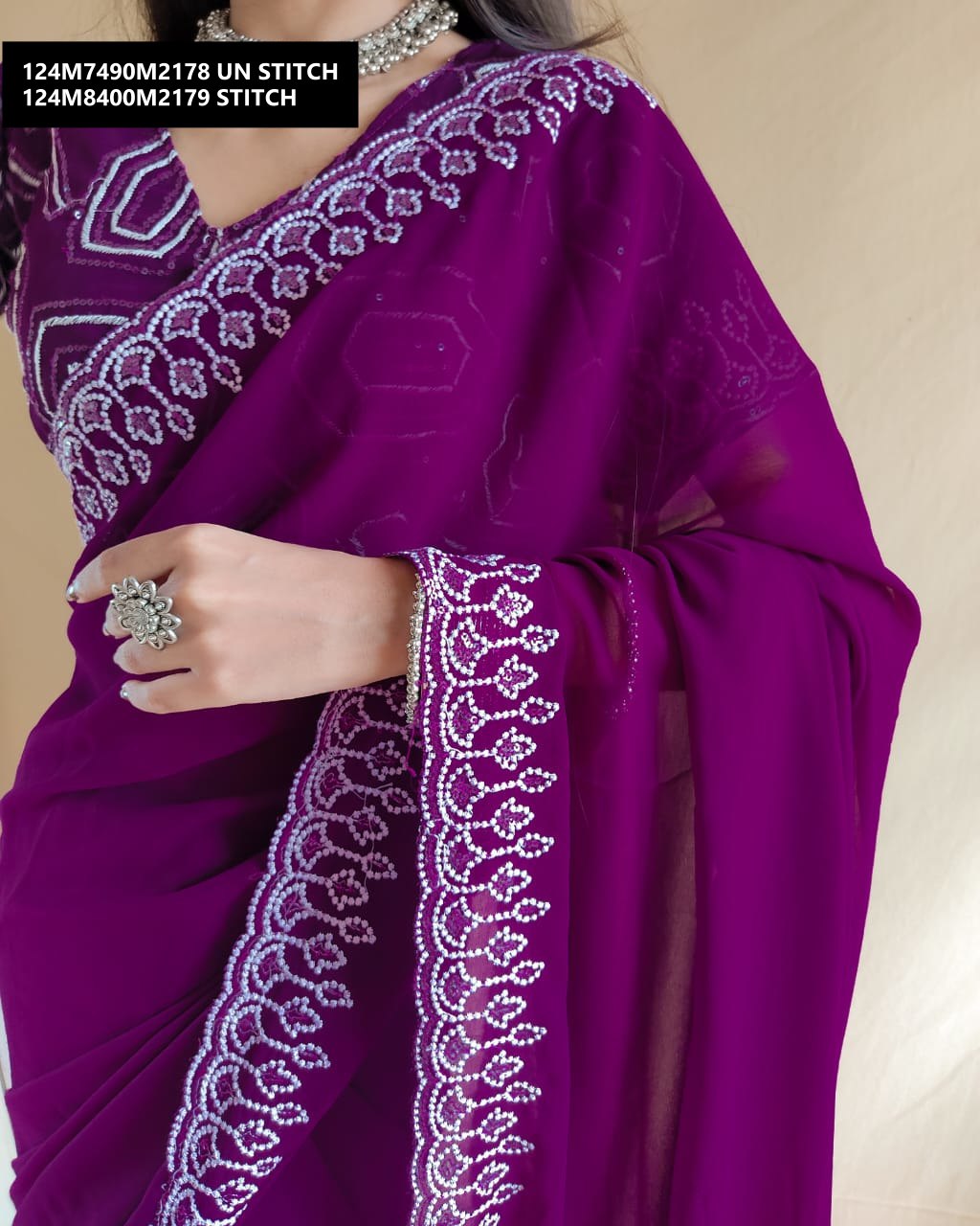 Model's torso and arm draped in the TRENDBUY deep purple georgette saree, highlighting the sequined Lucknowi border and intricate blouse sleeve.