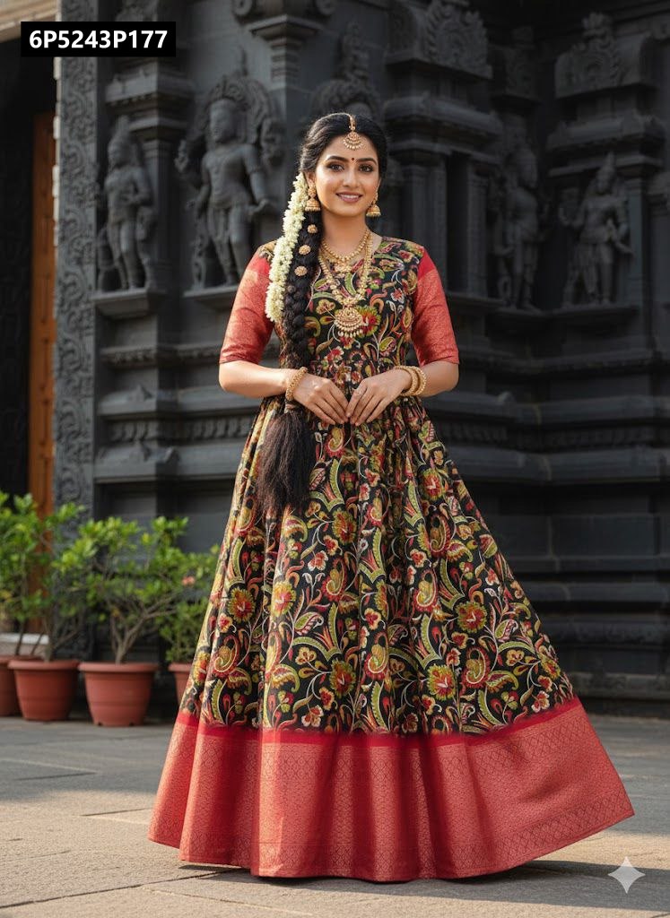 Model in black Dola Silk Anarkali gown with red floral print and red zari border, posing gracefully in front of a dark stone temple.