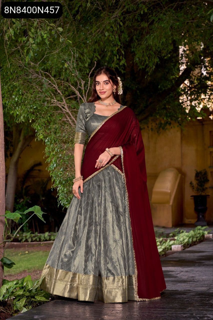 TRENDBUY model showcasing a grey Dupion silk lehenga with a rich maroon zari-embroidered dupatta, standing gracefully in a garden setting.