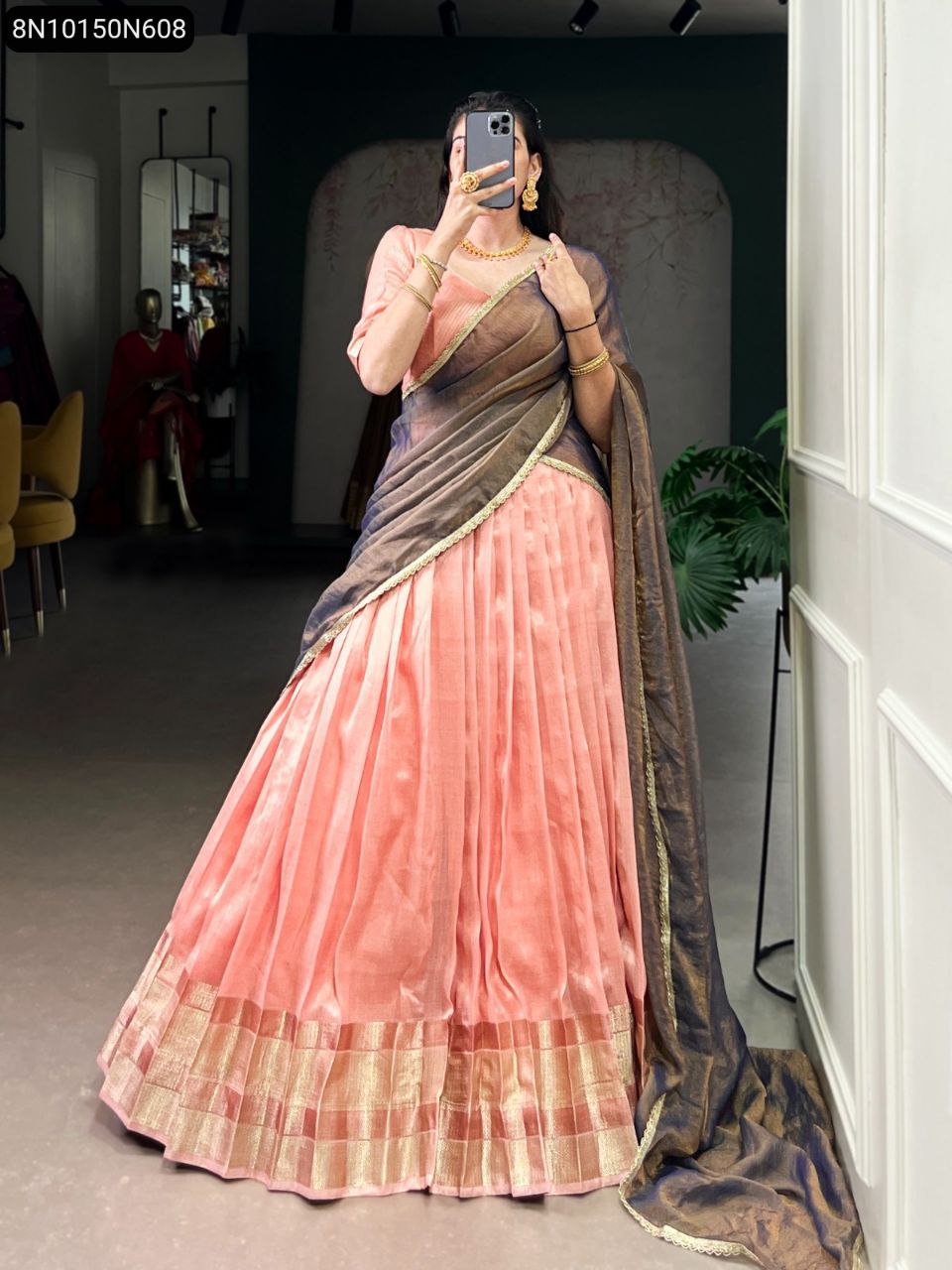 Model in peach dupion silk lehenga with zari weaving border and a contrasting dark grey shimmer dupatta, captured in a full-body shot indoors.