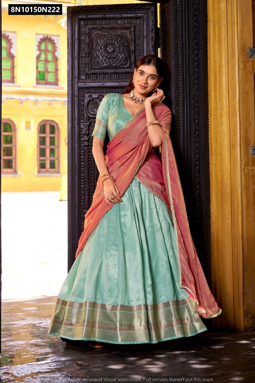 Model showcasing TRENDBUY Mint Green Dupion Silk Lehenga Choli with Peach Dupatta, standing gracefully at an antique doorway.
