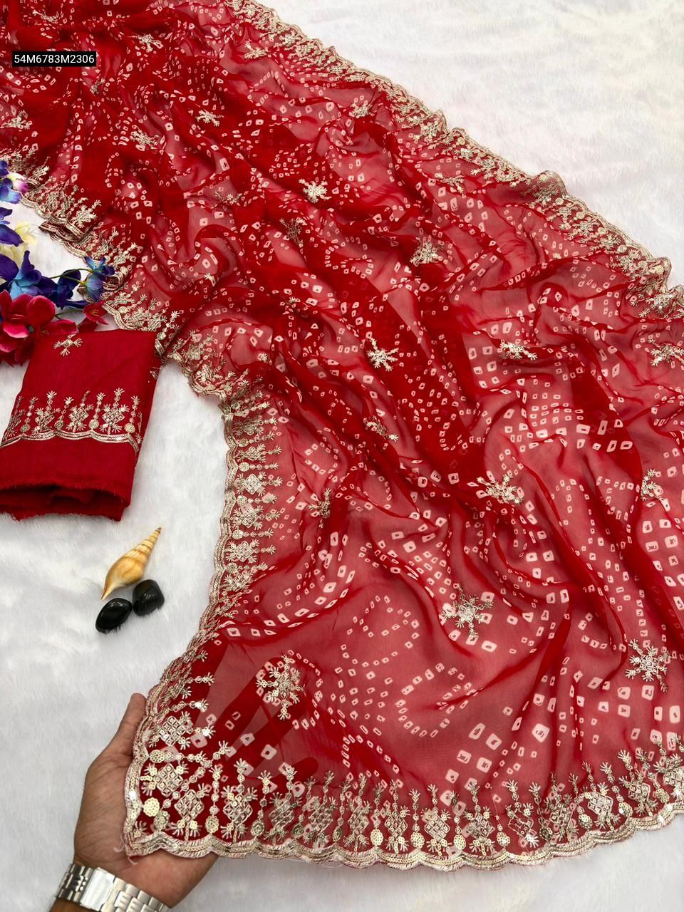 TRENDBUY Red Georgette saree with heavy gold and silver sequence border, traditional bandhani print, and matching unstitched blouse piece on a white surface, partially draped.