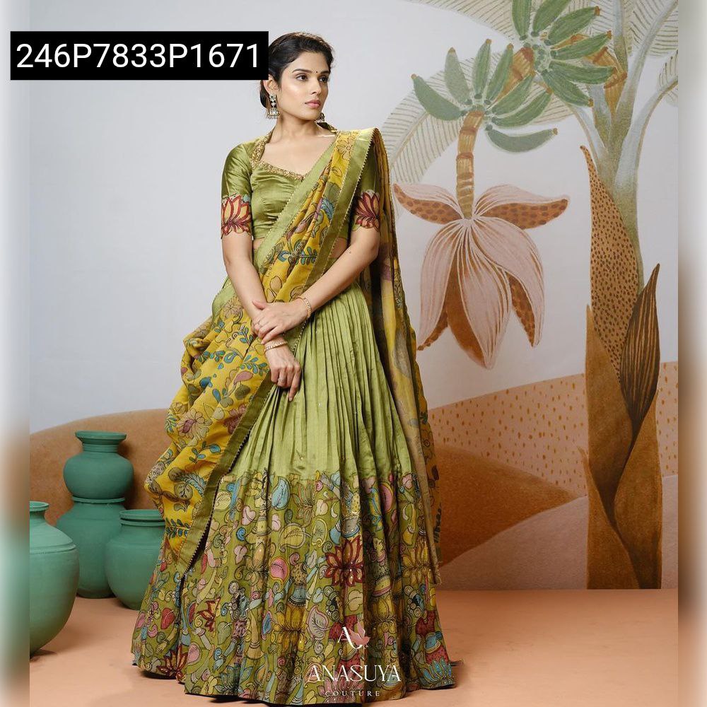Full-body shot of model standing confidently in TRENDBUY Olive Green Tussar Silk Lehenga Choli, displaying the full flair of the pleated lehenga with its vibrant Kalamkari border and matching dupatta.