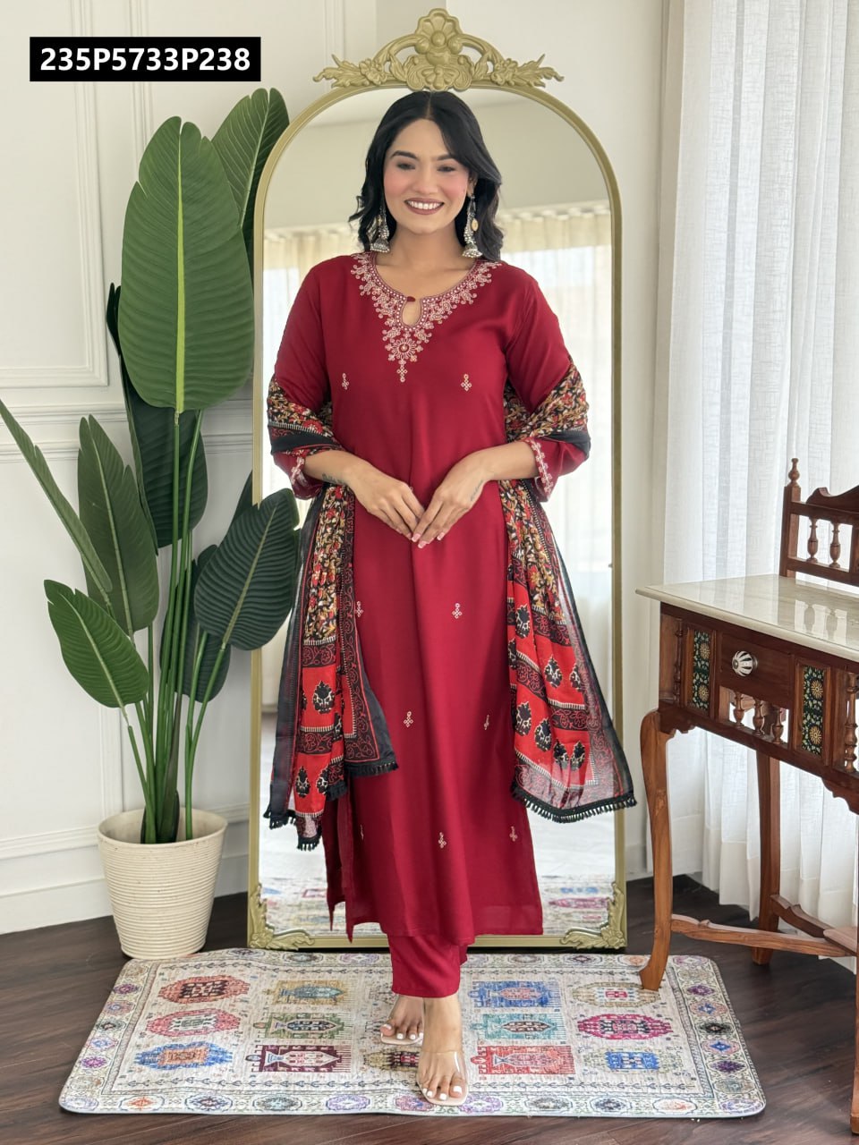 Model wearing a full-length red pure viscose rayon kurti set with intricate neckline embroidery and a black and red printed cotton blend dupatta.