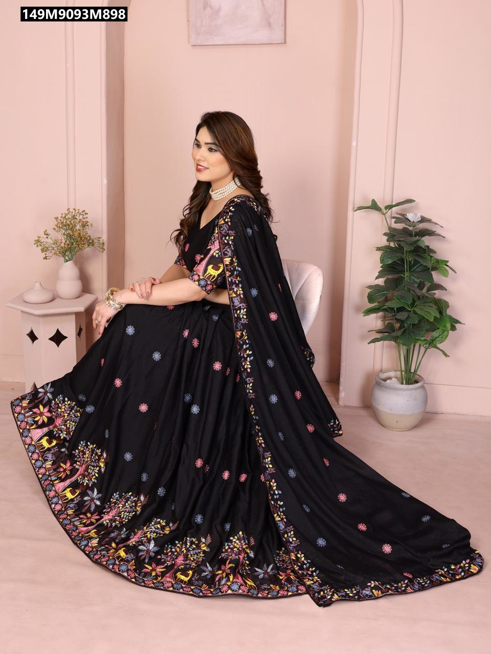 TRENDBUY model seated in a black Star Georgette embroidered lehenga choli set, showcasing its vibrant animal and floral motifs along the hem.