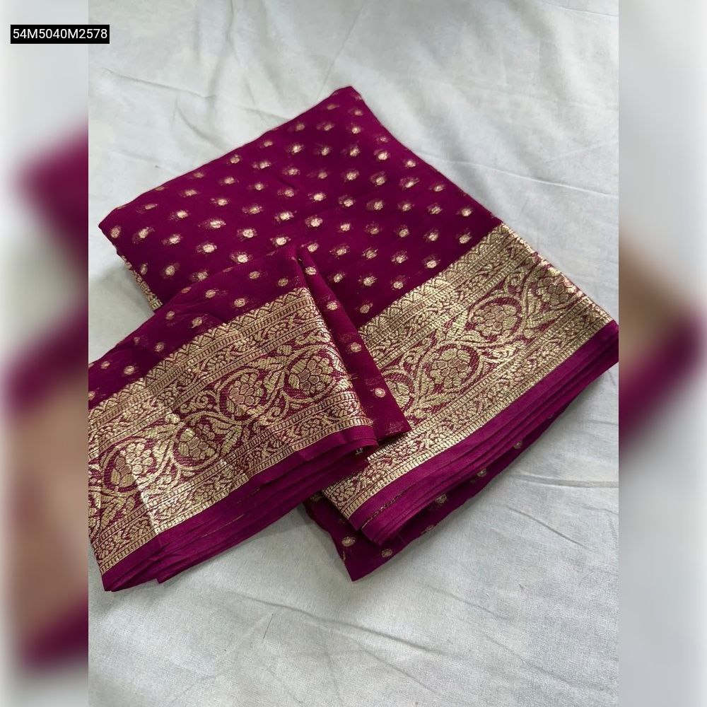 TRENDBUY Magenta Viscose Georgette Saree with gold zari buti and elaborate border, folded with matching blouse piece on white background.