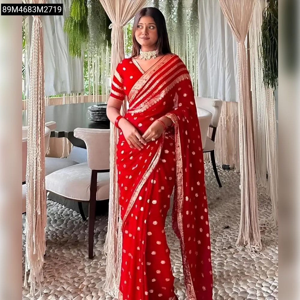 TRENDBUY Red Viscose Georgette Saree with gold zari polka dots and striped border, draped elegantly on a model in a relaxed indoor setting.