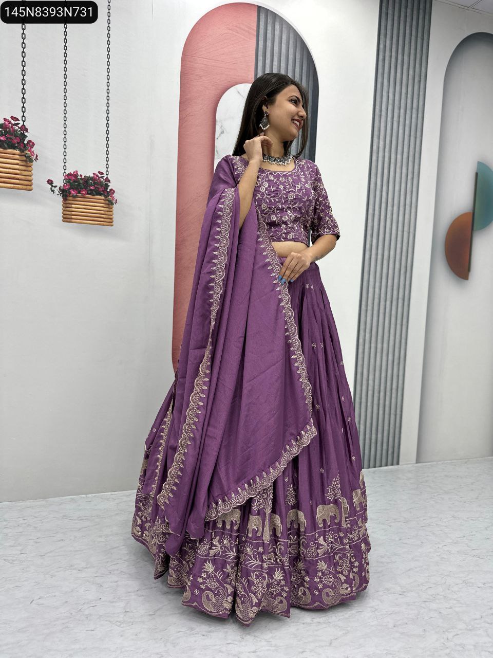 Model in a purple TRENDBUY Chinon lehenga choli set, featuring intricate gold elephant and floral embroidery, paired with a matching embroidered dupatta, posing elegantly.