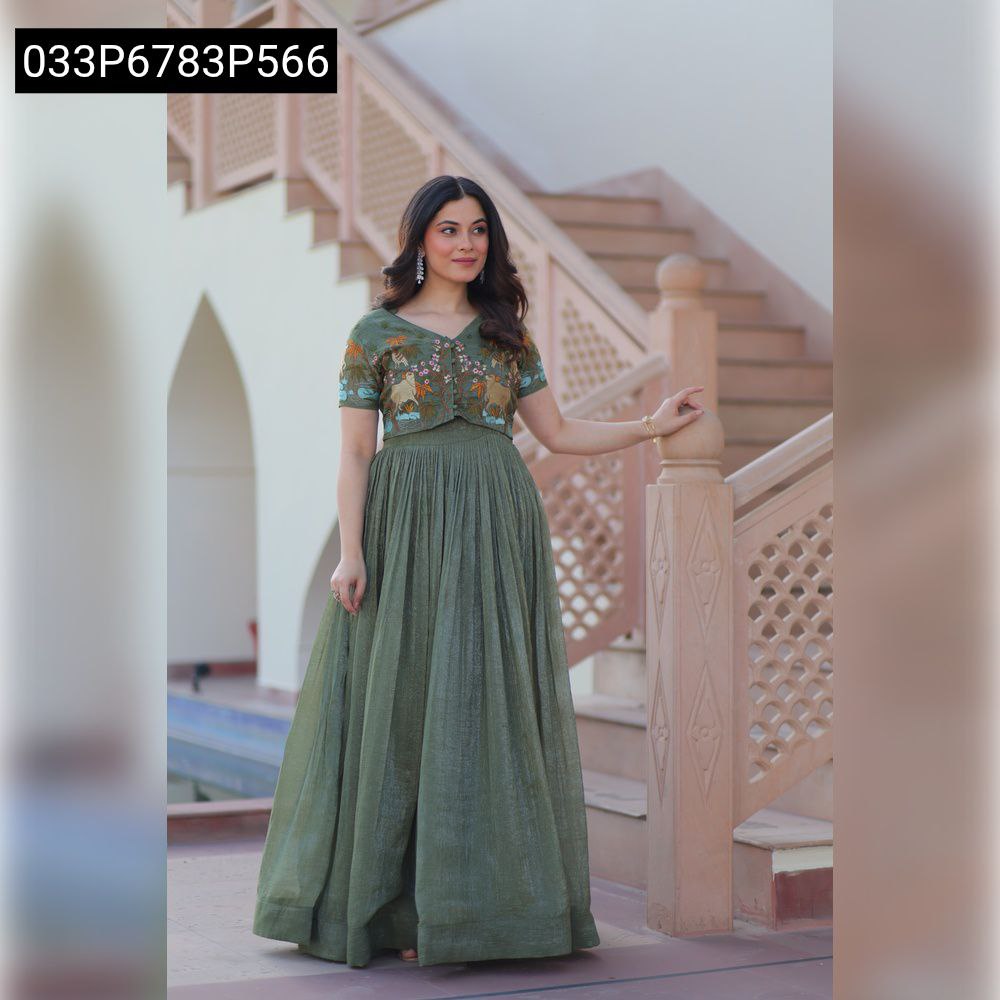 Full-length shot of a model gracefully posing in a TRENDBUY sage green crunchy fabric gown and embroidered Koti on a staircase.