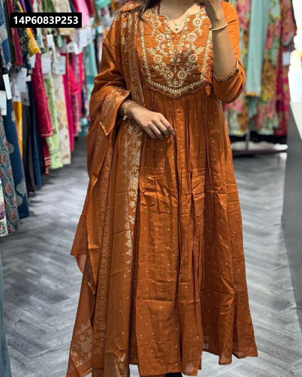 Full body shot of a model wearing a rust-colored TRENDBUY Reyon Cotton kurti set with embroidery and printed dupatta in a retail setting.