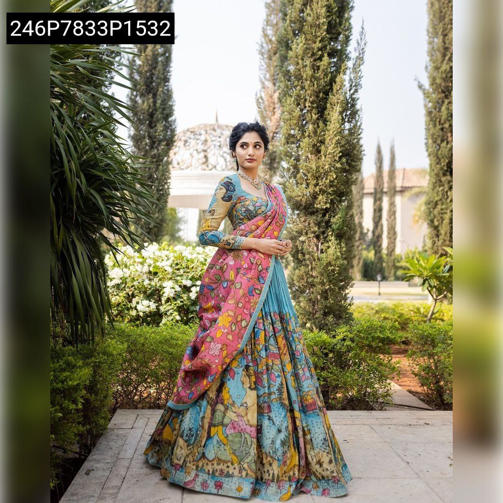TRENDBUY model gracefully posing in a vibrant blue Tussar silk Kalamkari print lehenga choli with pink dupatta, front view in a garden.
