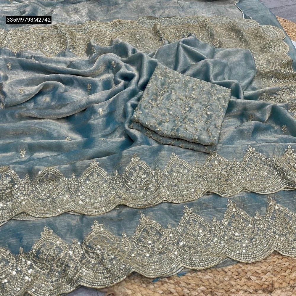 Teal Fendy Chiffon Saree with intricate gold 3MM sequence zari work and a scalloped Aarco border, paired with an unstitched embroidered blouse piece, spread on a rustic mat.