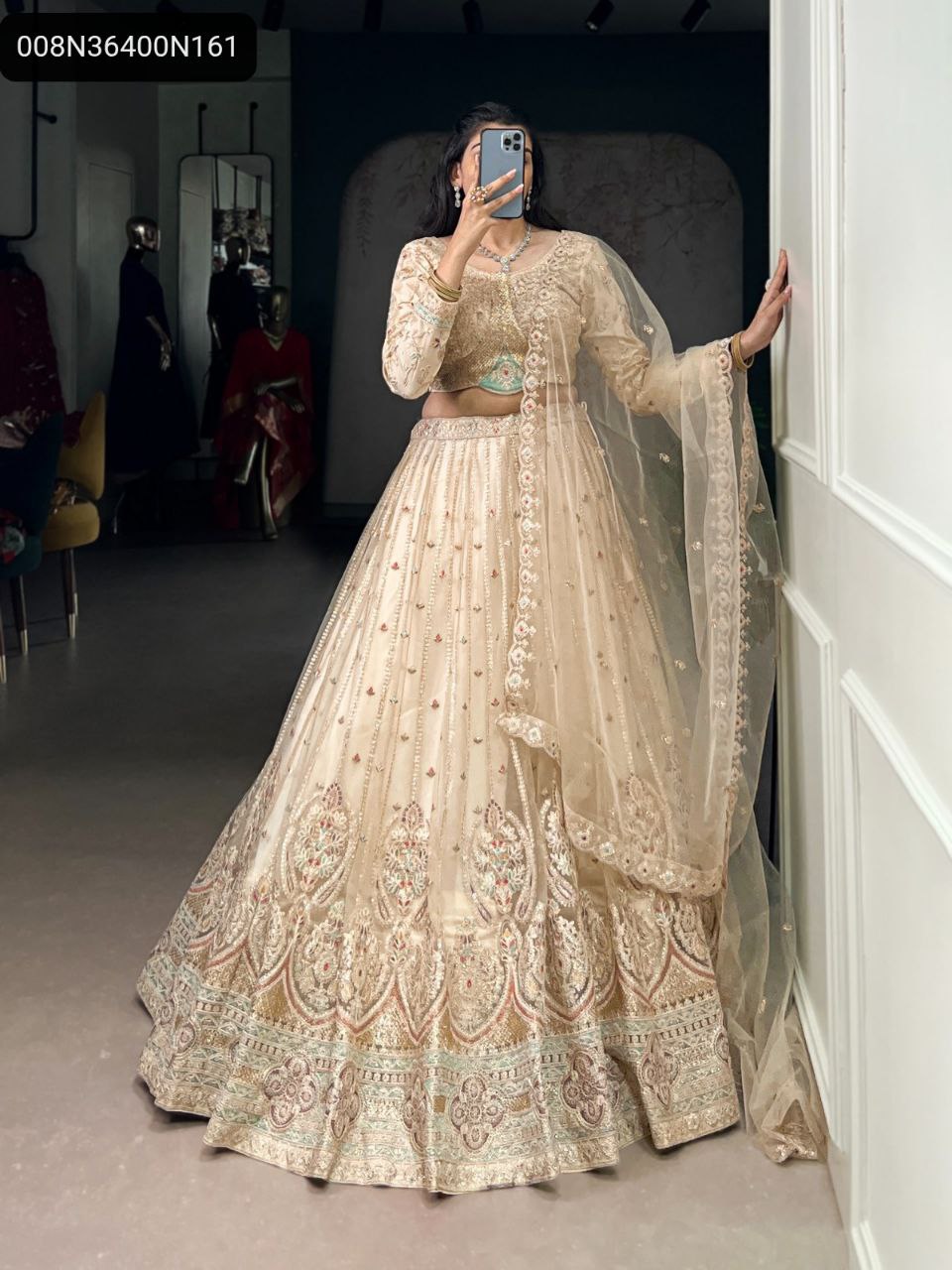 TRENDBUY Pastel Beige Net Lehenga Choli with full sequins and thread embroidery, modeled gracefully for a full-body front view.