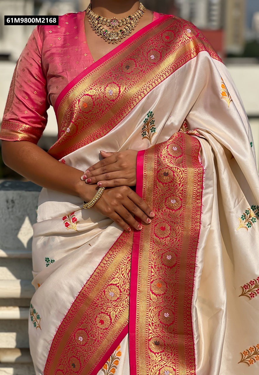 Close-up of model's hands on a Cream Soft Silk Saree, showing flower butta and pink-gold zari border details.