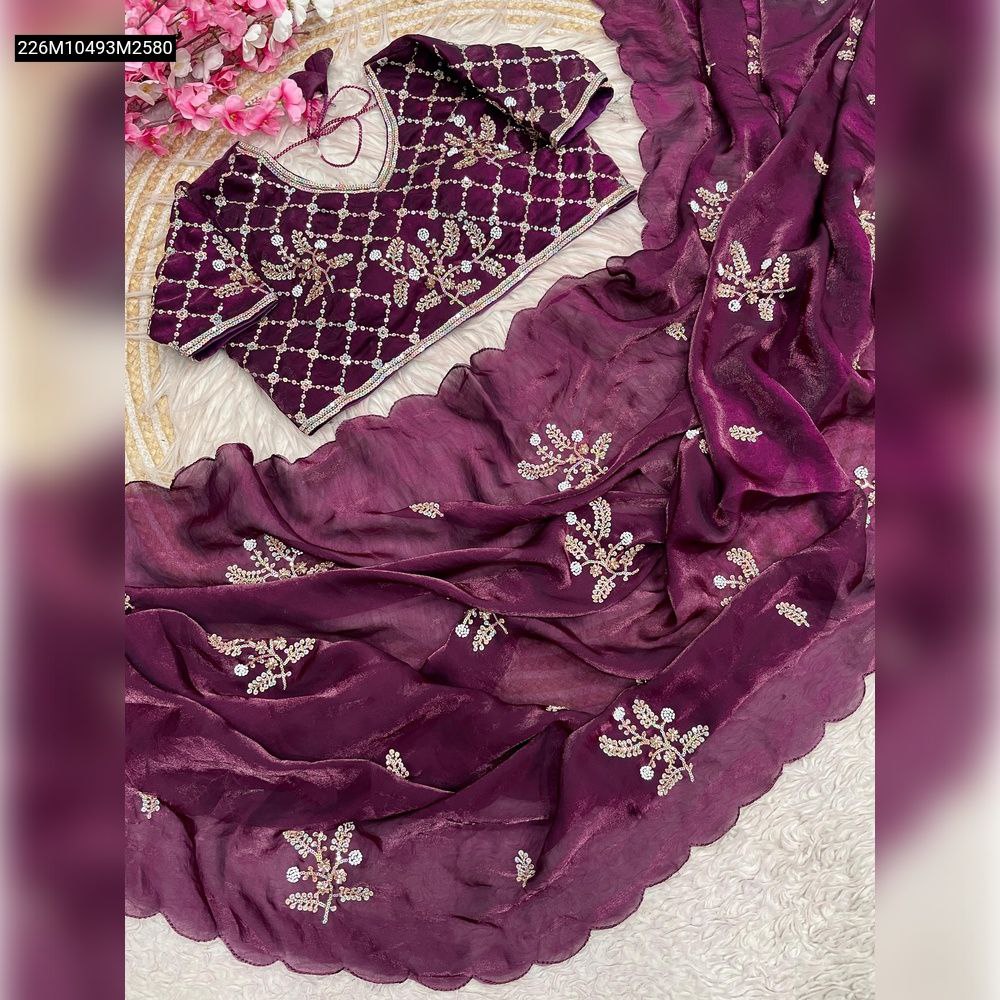 Overhead view of a deep purple TRENDBUY Fandy satin saree with intricate floral khatli brits work and a matching embellished blouse on a textured white surface.