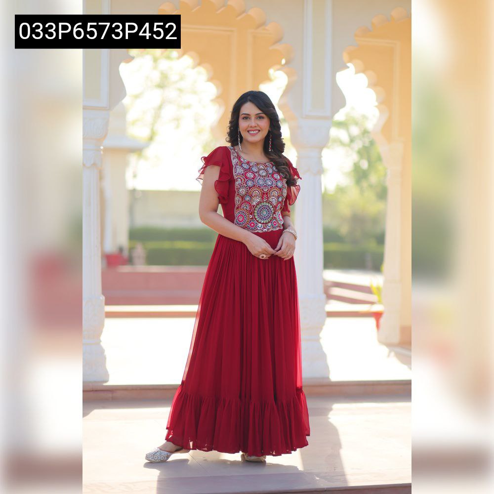 Full body shot of a smiling model in the TRENDBUY maroon embroidered faux blooming gown, standing gracefully under an archway, showcasing the full length and frill hem.