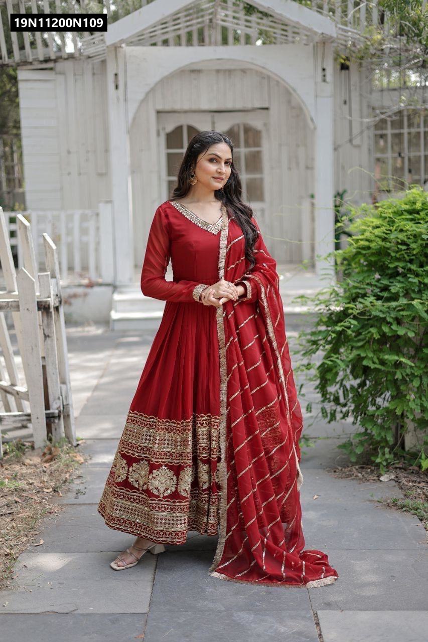 Model in a maroon faux blooming gown with gold sequin embroidery and matching dupatta, standing confidently outdoors.