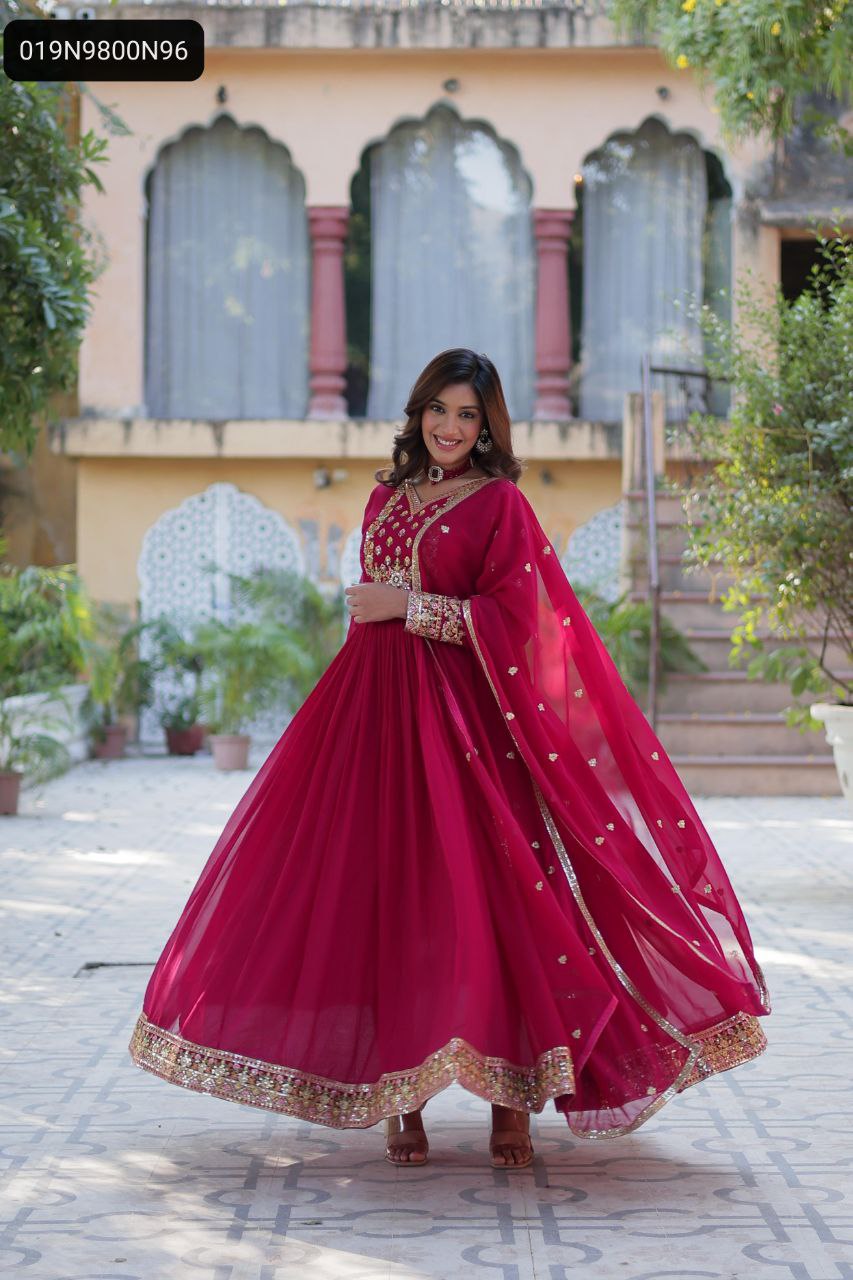 Main Image: Elegant TRENDBUY maroon faux blooming georgette gown with rich sequins and embroidered work, model twirling, showcasing full flair and matching dupatta, perfect for festive occasions.