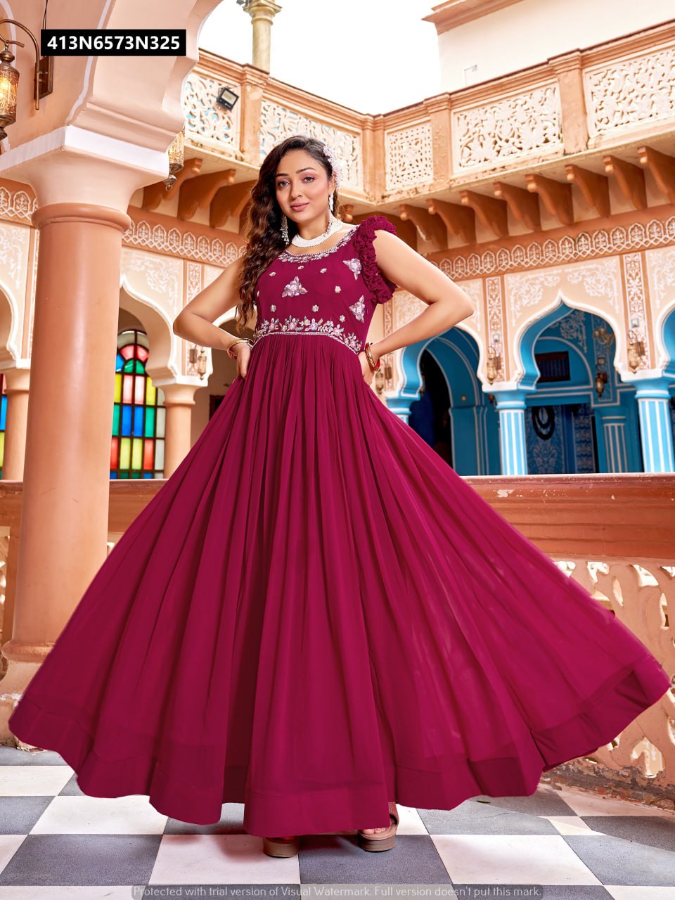 Full-length shot of a model gracefully posing in a vibrant Rani (deep red) faux blooming designer gown, showcasing its impressive 3.5 meter flair and intricate embroidery.