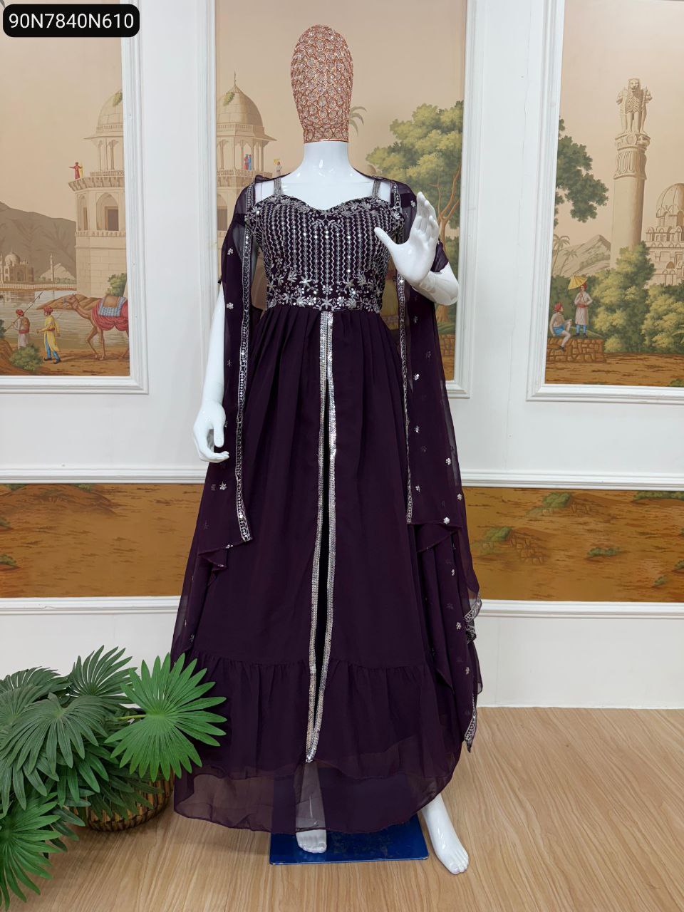 Full-body mannequin shot of the TRENDBUY deep plum purple faux georgette embroidered lehenga with koti and dupatta, set against a painted wall backdrop.