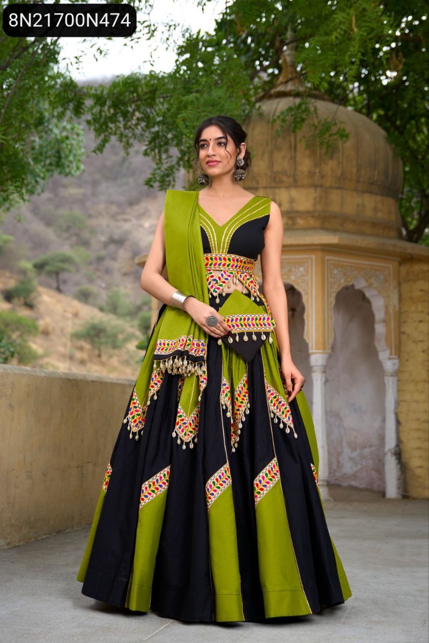 TRENDBUY model showcasing a black and lime green pure cotton lehenga choli set with colorful Gamthi work and cowrie lace, standing elegantly against a traditional architectural backdrop.