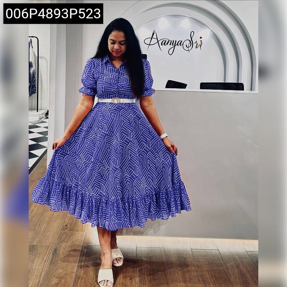 TRENDBUY woman modeling a royal blue fox georgette maxi dress with white geometric patterns and a white belt, standing in a brightly lit room.