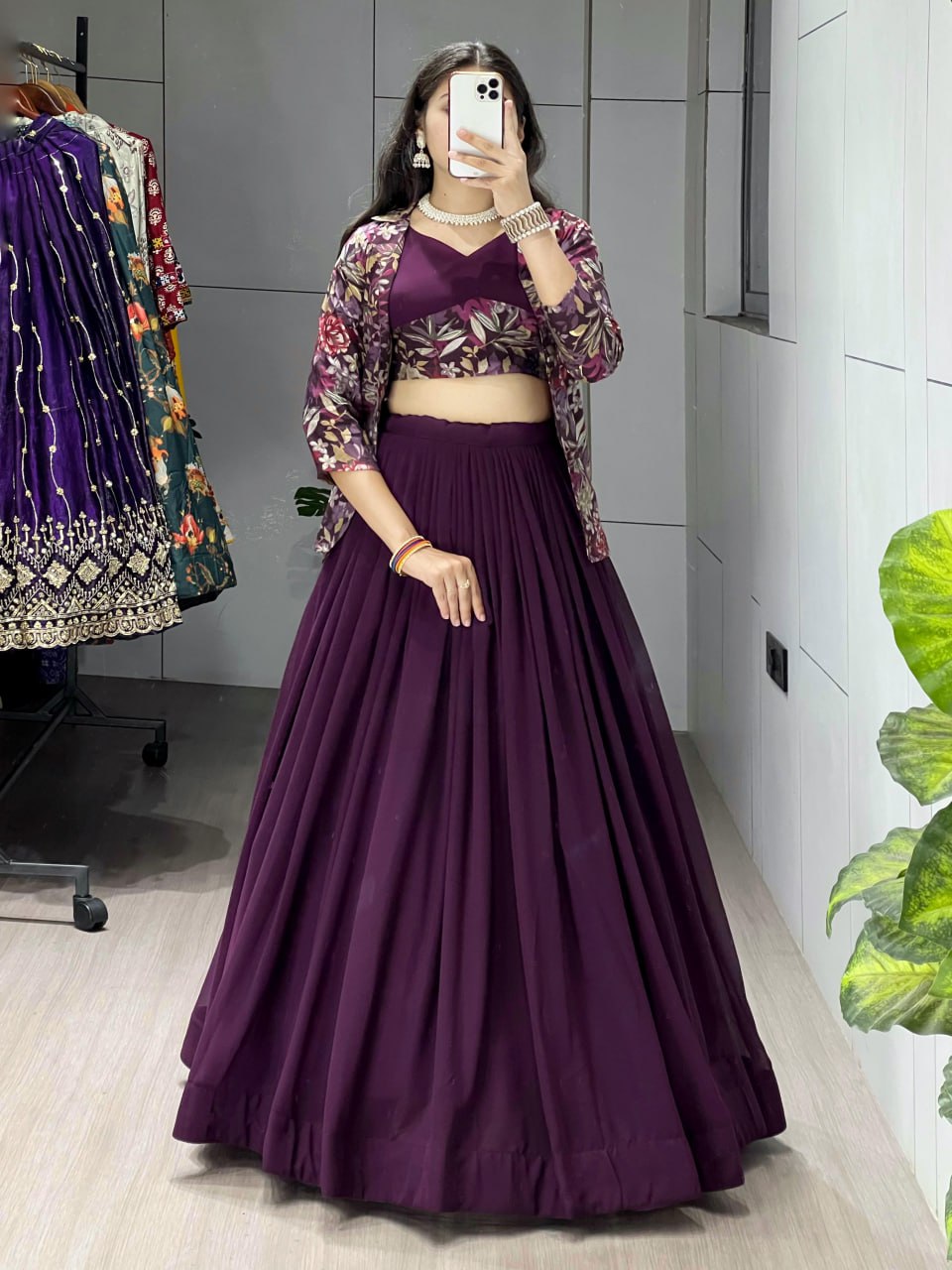 Full body shot of a model wearing the TRENDBUY Plum Purple Georgette Lehenga Choli with a floral print Viscose Chanderi Koti jacket, posing elegantly.
