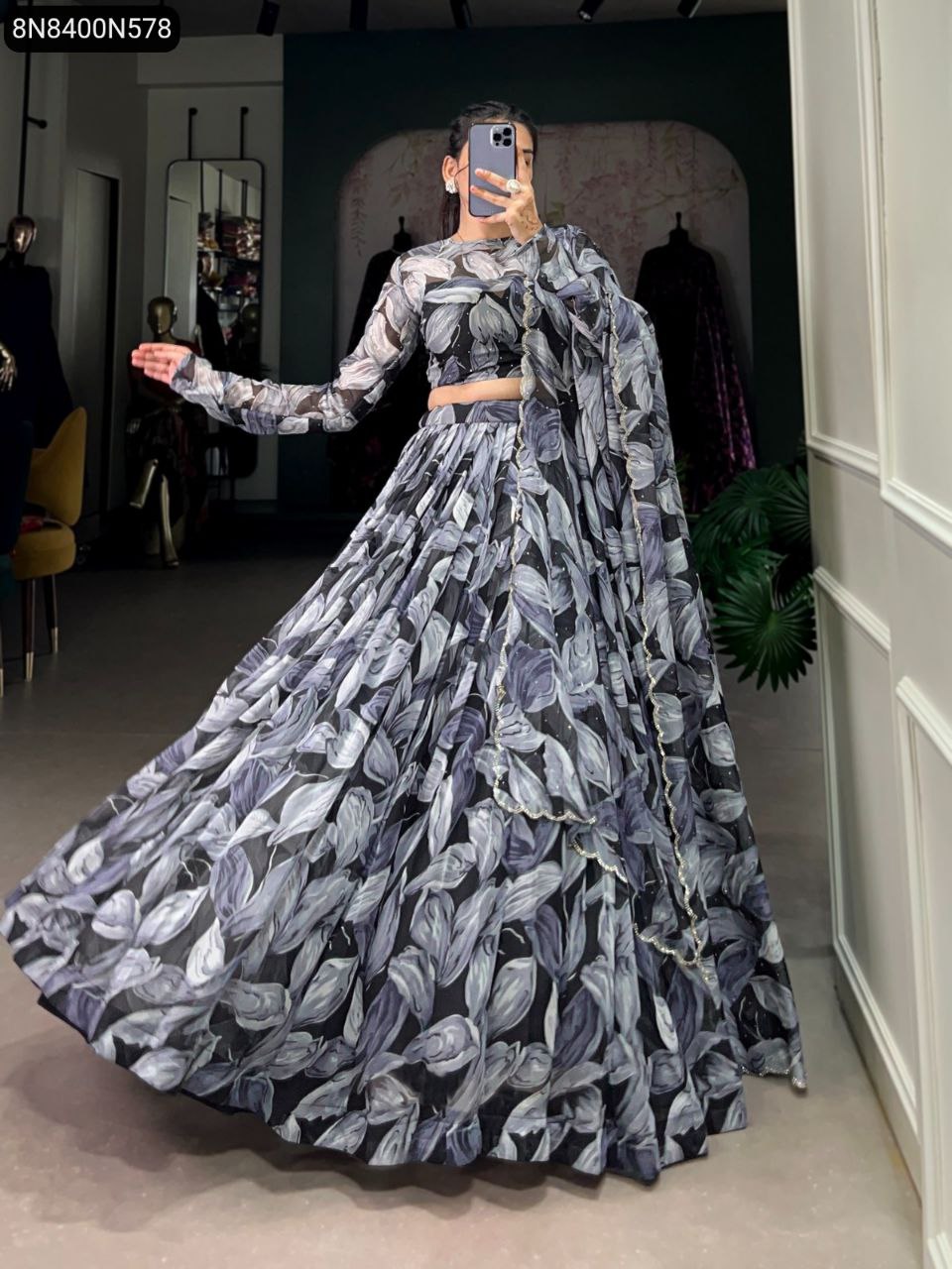 Full body shot of model gracefully twirling in TRENDBUY black and grey leaf print Tabby Silk Lehenga Choli with dupatta, highlighting the wide flair.