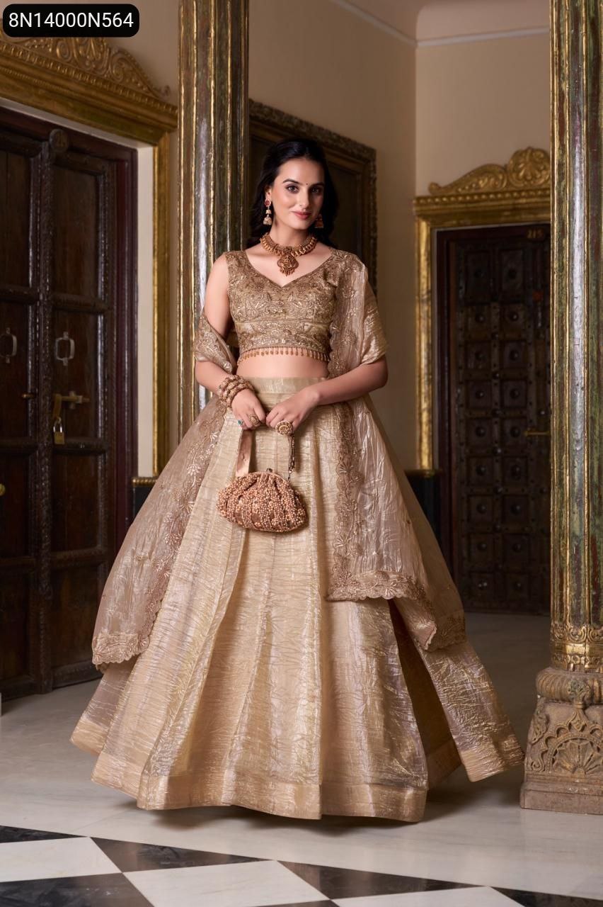 Full body view of model gracefully posing in TRENDBUY gold crush embroidered lehenga choli set, holding a matching clutch.