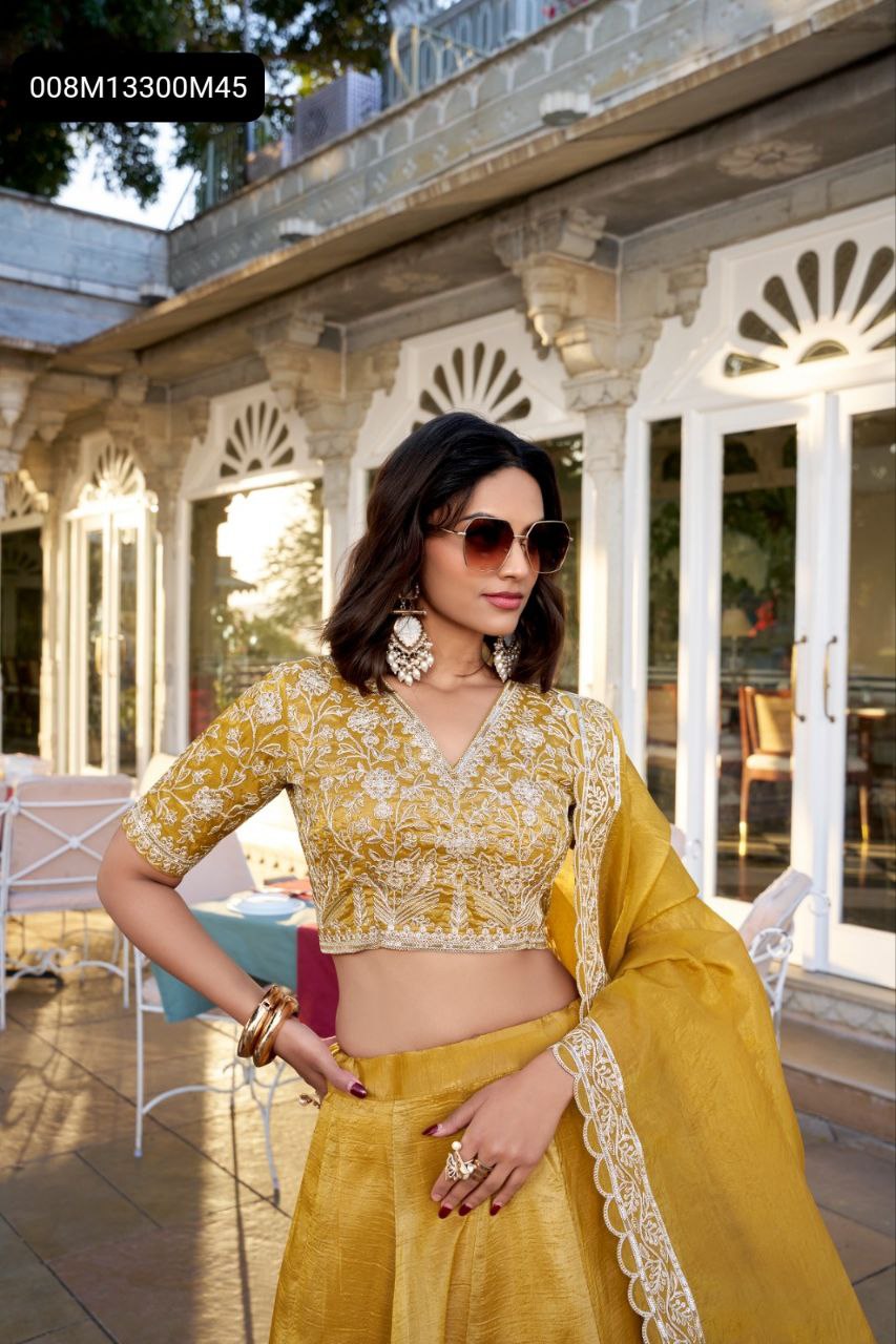 Close-up of model wearing TRENDBUY Golden Goldie Lehenga Choli, showcasing the intricate sequin and thread embroidered V-neck blouse, statement earrings, and stylish sunglasses on a sunlit patio.