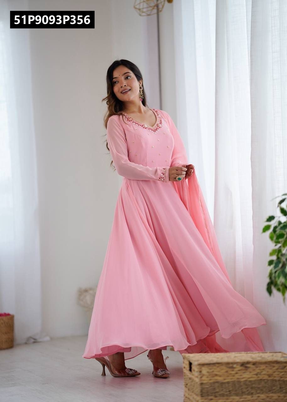 Full body shot of model in flowing light pink georgette gown, showcasing 8-meter flair, standing elegantly by a sheer curtain.