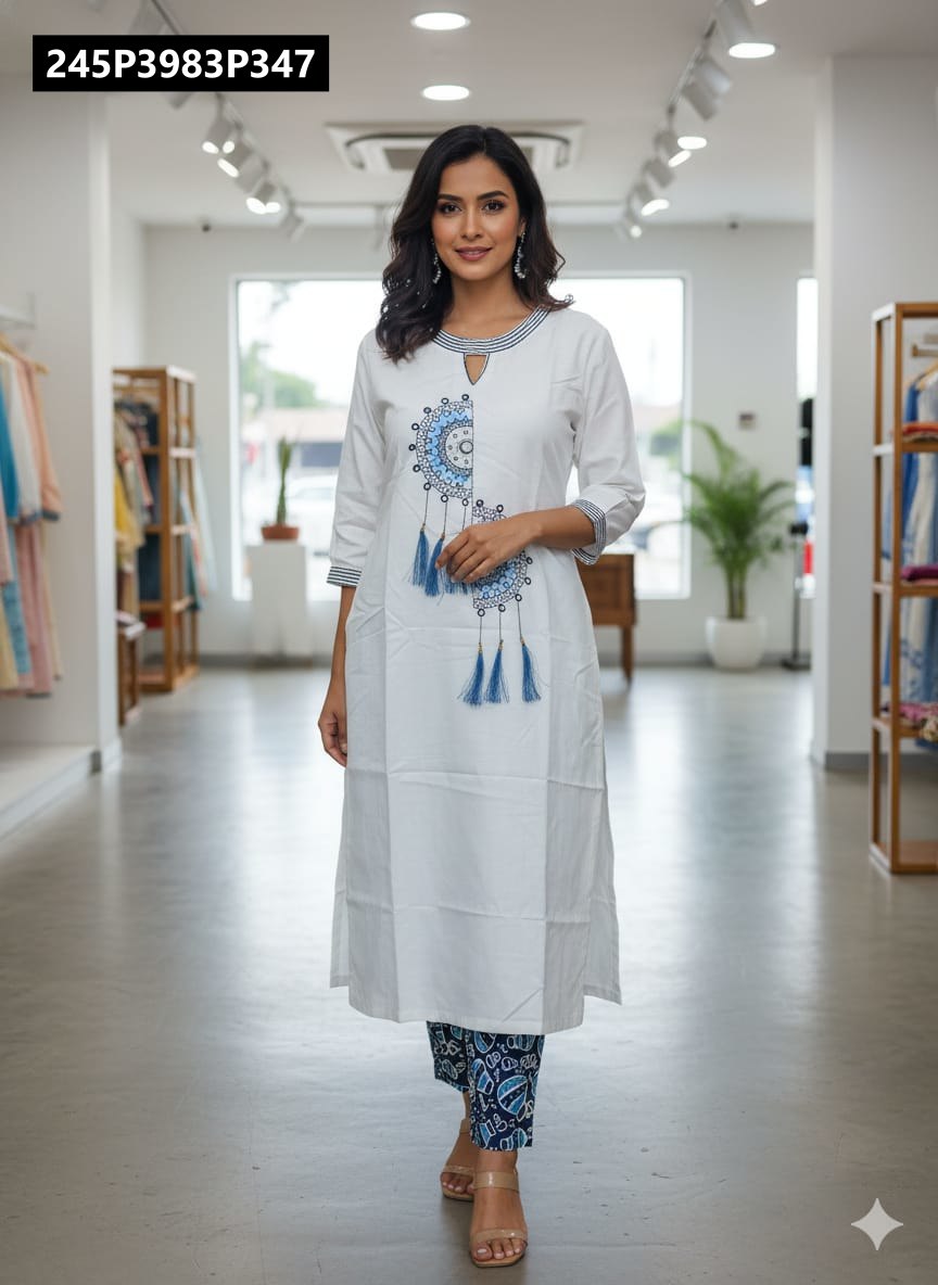 TRENDBUY woman modeling white cotton flex kurta with blue mandala embroidery and tassels, paired with blue printed pants, full front view in a boutique.