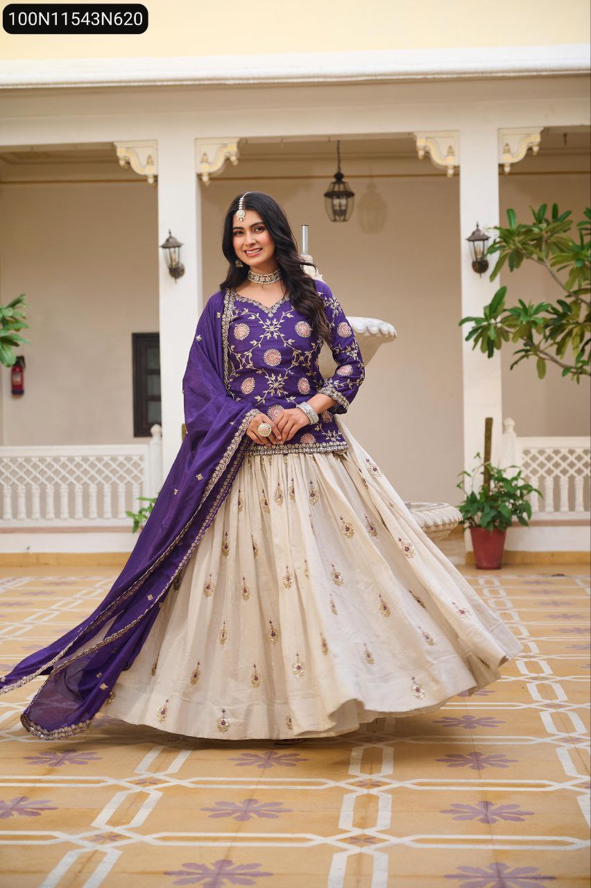 TRENDBUY model in purple embroidered kurti and off-white tissue silk lehenga with dupatta, posing elegantly outdoors with traditional jewelry.