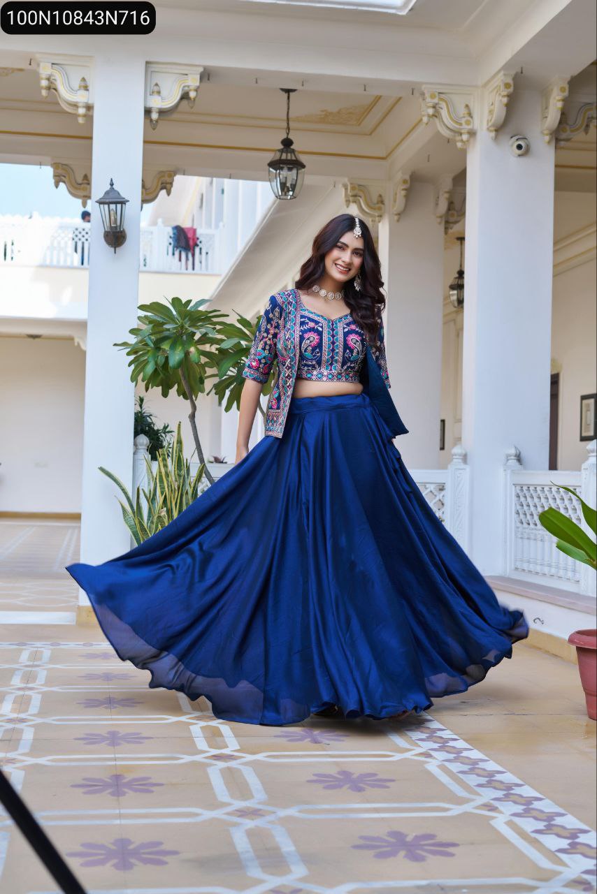 A joyful model twirling in a TRENDBUY royal blue embroidered Vichitra Lehenga Choli Koti set, highlighting the lehenga's generous flair in a palace courtyard.